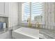 Kitchen sink area features gold fixtures, white cabinets, marble countertops and backsplash, and a view to the outside at 1170 Gulf Blvd # 2001, Clearwater, FL 33767