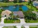 Aerial view of a home with backyard pond and mature trees in a beautiful residential neighborhood at 12333 Woodlands Cir, Dade City, FL 33525