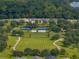 Aerial view of the community park featuring tennis courts, a playground, basketball court, and walking trail at 12333 Woodlands Cir, Dade City, FL 33525