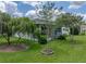 The backyard showcases beautiful trees and lush green lawn at 12333 Woodlands Cir, Dade City, FL 33525