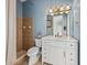 Bathroom with a white vanity, tiled shower, and blue walls at 12333 Woodlands Cir, Dade City, FL 33525