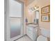 Bathroom featuring a modern vanity, mirror, and access door to the backyard at 12333 Woodlands Cir, Dade City, FL 33525