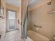 Bathroom with a bathtub/shower combo and access door to the backyard at 12333 Woodlands Cir, Dade City, FL 33525