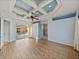Bright bedroom features an eye-catching tray ceiling, wood floors, and doors to the pool and bathroom at 12333 Woodlands Cir, Dade City, FL 33525