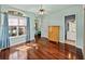 Well-lit room with hardwood floors, large window and curtains, offering views of the yard at 12333 Woodlands Cir, Dade City, FL 33525