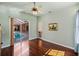 Bedroom with hardwood floors, a ceiling fan, and sliding glass doors that lead to an outdoor pool at 12333 Woodlands Cir, Dade City, FL 33525