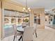 Charming breakfast nook with a chandelier overlooks a screened pool area with easy access through sliding glass doors at 12333 Woodlands Cir, Dade City, FL 33525