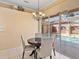 Cozy breakfast nook showcases a round dining table with views of the sparkling screened-in pool at 12333 Woodlands Cir, Dade City, FL 33525