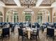 A dining room has large windows, multiple tables, and blue chairs at 12333 Woodlands Cir, Dade City, FL 33525
