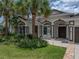 Charming home showcasing a well-kept lawn and inviting entryway, enhanced by lush landscaping and palm trees at 12333 Woodlands Cir, Dade City, FL 33525