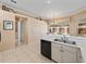 Bright kitchen features tile floors, white cabinets, and a stainless steel double sink with a window view at 12333 Woodlands Cir, Dade City, FL 33525