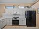 Updated kitchen showcases white cabinets, granite countertops, and black appliances at 12333 Woodlands Cir, Dade City, FL 33525