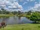 View of a beautiful pond with fountain and lush landscaping at 12333 Woodlands Cir, Dade City, FL 33525