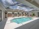 Stunning screened-in pool with a spa and elegant tile work, perfect for outdoor relaxation and entertainment at 12333 Woodlands Cir, Dade City, FL 33525