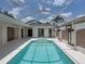 Spacious screened-in pool area with a spa and easy access to the house through sliding glass doors at 12333 Woodlands Cir, Dade City, FL 33525