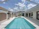 Large screened-in pool with spa and elegant architectural details creating a luxurious outdoor entertainment space at 12333 Woodlands Cir, Dade City, FL 33525