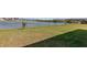 The backyard has a large lawn and a chain link fence with a lake beyond at 1308 22Nd E St, Palmetto, FL 34221
