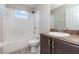 Bright bathroom featuring a single vanity and a bathtub with white tiled walls and wood look flooring at 1308 22Nd E St, Palmetto, FL 34221