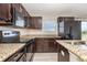 Modern kitchen featuring granite countertops, stainless steel appliances, and dark wood cabinets at 1308 22Nd E St, Palmetto, FL 34221