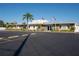 Low-rise community clubhouse with ample parking, stone accents, and dual flag poles under blue sky at 13225 101St St # 462, Largo, FL 33773