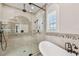 A luxurious bathroom features a soaking tub and a glass-enclosed shower with mosaic tile accents at 1336 51St Ne Ave, St Petersburg, FL 33703