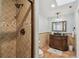 Bathroom featuring stone shower, mosaic tile accents, and a vintage vanity with dark stone countertops at 1336 51St Ne Ave, St Petersburg, FL 33703