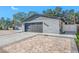 Side view of a gray brick home featuring a brick driveway and a two car garage at 16324 Bonneville Dr, Tampa, FL 33624