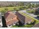 Aesthetic aerial view of an orange home featuring a dark brown roof and scenic landscaping at 17596 Terrazzo Way, Land O Lakes, FL 34638