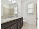 Bathroom with a granite countertop, dark cabinets, and a tile floor at 17596 Terrazzo Way, Land O Lakes, FL 34638