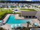 Aerial view of a community pool with lounge chairs, umbrellas, and a covered seating area in a neighborhood at 17596 Terrazzo Way, Land O Lakes, FL 34638