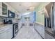Spacious kitchen with stainless steel appliances, marble floors, and white cabinets overlooking the living area at 212 Arbor Woods Cir, Oldsmar, FL 34677