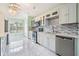 Updated kitchen with white cabinets, stainless steel appliances, mosaic backsplash, and marble flooring at 212 Arbor Woods Cir, Oldsmar, FL 34677