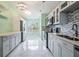 Modern kitchen featuring white cabinets, stainless steel appliances, mosaic backsplash, and marble floors at 212 Arbor Woods Cir, Oldsmar, FL 34677