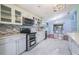 Well-lit kitchen featuring stainless steel appliances, a stylish backsplash, white cabinets, and marble floors at 212 Arbor Woods Cir, Oldsmar, FL 34677