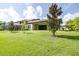 Expansive backyard featuring lush lawn, mature trees, and screened in pool enclosure at 21807 Amelia Rose Way, Land O Lakes, FL 34637