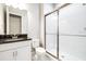 Bathroom featuring walk-in shower with glass door and white cabinets at 21807 Amelia Rose Way, Land O Lakes, FL 34637
