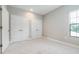 Bedroom with neutral walls, light carpet, and two double door closets at 21807 Amelia Rose Way, Land O Lakes, FL 34637