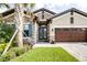 Beautiful home with a stone facade, double front doors, three-car garage and a paver driveway at 21807 Amelia Rose Way, Land O Lakes, FL 34637