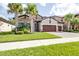 Charming two-story home featuring stone accents, a manicured lawn, and a spacious three-car garage at 21807 Amelia Rose Way, Land O Lakes, FL 34637