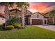 Exterior shot of a single Gathering home, with manicured lawn, 2 car garage and stone facade at 21807 Amelia Rose Way, Land O Lakes, FL 34637