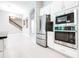 Open concept kitchen features stainless steel appliances, modern finishes and view of the staircase at 21807 Amelia Rose Way, Land O Lakes, FL 34637