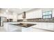 Gourmet kitchen boasts an expansive island, sleek countertops, stylish backsplash, and modern white cabinets at 21807 Amelia Rose Way, Land O Lakes, FL 34637