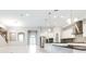 Open-concept living room and kitchen with stainless steel appliances, granite counters and island at 21807 Amelia Rose Way, Land O Lakes, FL 34637