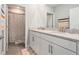 Bathroom featuring double sinks, vanity with granite countertop, framed mirrors, and a shower at 22990 Scaglione Dr, Lutz, FL 33549