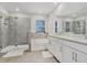 Luxurious bathroom featuring a glass-enclosed shower, soaking tub, double vanity, and elegant finishes at 22990 Scaglione Dr, Lutz, FL 33549