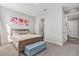 This bedroom features neutral walls, artwork and a cushioned bench at the foot of the bed at 22990 Scaglione Dr, Lutz, FL 33549