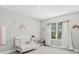 Charming Bedroom featuring playful wall decor, a crib, and natural light at 22990 Scaglione Dr, Lutz, FL 33549