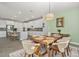 A dining area features a wooden table with six chairs, accented by a modern light fixture and stylish rug at 22990 Scaglione Dr, Lutz, FL 33549