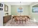 Charming dining room with a wooden table set for six, with decorative chandelier, and soft green walls at 22990 Scaglione Dr, Lutz, FL 33549