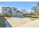 Two-story home featuring a brick driveway, two-car garage, manicured lawn, and modern architectural design at 22990 Scaglione Dr, Lutz, FL 33549